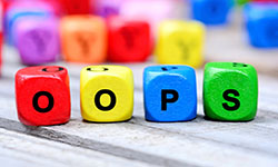 Four letter dice spell out the word OOPS